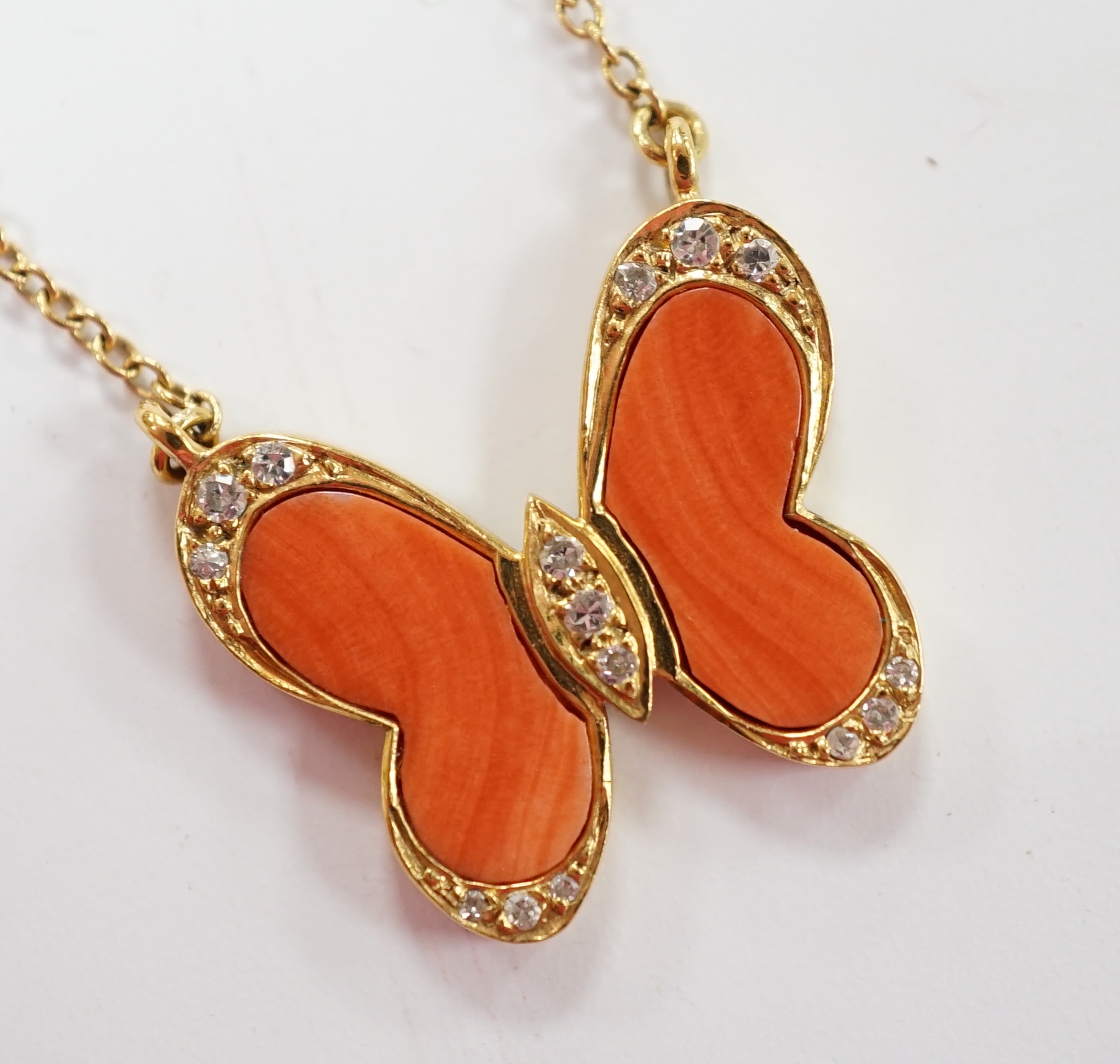 A modern 18ct gold, coral and diamond chip set butterfly necklace, 40cm, gross weight 6.4 grams. Good condition.